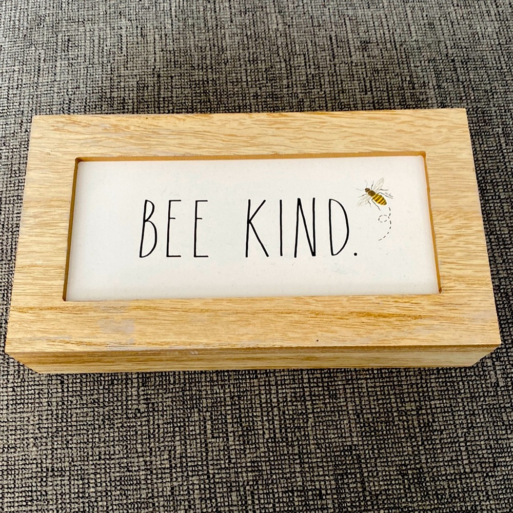 Rae Dunn. “Bee Kind” wall art. White with black print writing.